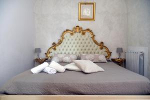 1 dormitorio con cama con marco de oro y almohadas en Case Vacanze La Conia, en Cannigione