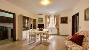 a living room with a table and a kitchen at Casa Antonietta in Orosei