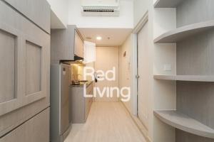 a hallway leading to a kitchen with a red living sign at Redliving Apartemen Springlake Summarecon - MDH Rooms Tower Caldesia with Netflix in Bekasi