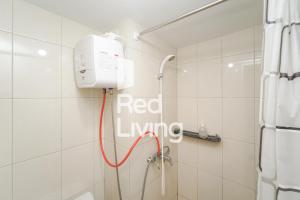 a bathroom with a red living sign on the wall at Redliving Apartemen Springlake Summarecon - MDH Rooms Tower Caldesia with Netflix in Bekasi