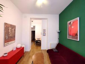 un soggiorno con divano rosso e parete verde di MEZZANINe GREEN a Madrid