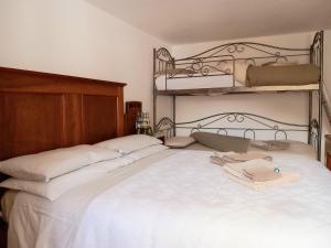 a bedroom with a white bed with two bunk beds at Cjasa da Puci in Ovaro +28 photos