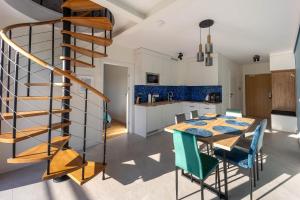 une cuisine et une salle à manger avec une table en bois et un escalier en colimaçon dans l'établissement SEA Apartment Porto Łeba, à Łeba