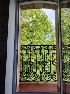 una puerta abierta a un balcón con una puerta de hierro forjado en Villa Garona avec billard proche Pyrénées en Cazères