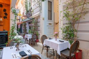 a restaurant with tables and chairs in a courtyard at 2 Mazi Suites in Athens
