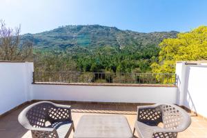 a patio with two chairs and a table on a balcony at Alojamiento Rural Arco Iris in Arroyo Frio