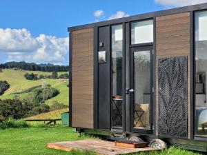 a tiny house on a trailer in a field at Deloraine Tiny Retreat in Whangarei
