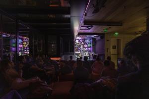 Une foule de personnes assises dans une pièce avec scène dans l'établissement Wabi Sabi Hostel Istanbul, à Istanbul