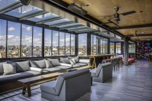 a large room with couches and tables and windows at Wabi Sabi Hostel Istanbul in Istanbul