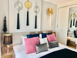 a bedroom with a bed with pink and blue pillows at Amazing View The Astra Sky River, Chiang Mai in Chiang Mai