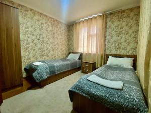 una camera con due letti e una finestra di Mountain Base ARTUCH a Panjakent