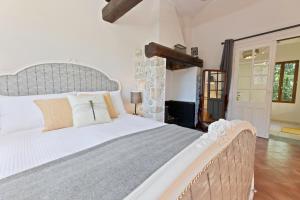 a bedroom with a large bed with a stone wall at Petit Murier in Boisredon