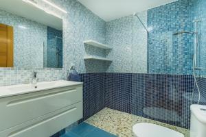 een badkamer met een wastafel, een douche en een toilet bij Dúplex junto a la playa in Sanlúcar de Barrameda