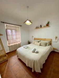 sypialnia z dużym białym łóżkiem z ręcznikami w obiekcie Amal Casa de huéspedes w Kordobie