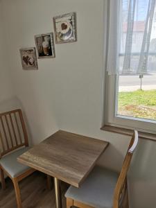 a table and two chairs and a table and a window at Ferienwohnung Paulinzella 9 inklusive Parkplatz und WLAN in Königsee