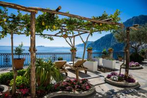 a patio with flowers and a view of the ocean at YourHome - Villa Aldo Marino in Positano