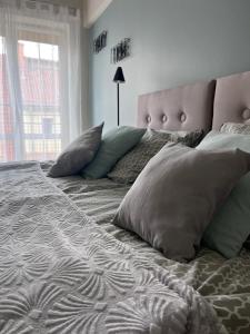 sypialnia z dużym łóżkiem z poduszkami w obiekcie Apartament Boya w mieście Giżycko
