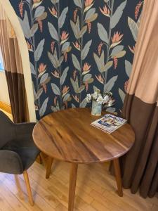 einen Holztisch mit einer Vase aus Blumen und einem Stuhl in der Unterkunft The Captains Quarters in Berwick-Upon-Tweed