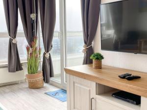 a living room with a tv and a window at Frische-Brise-06-05 in Cuxhaven