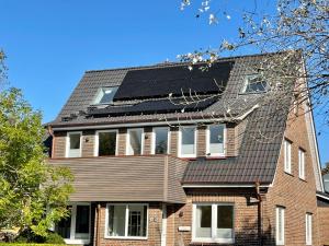 a house with solar panels on the roof at Ferienwohnung '2' im OTTEN in Langeoog