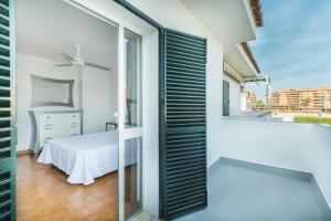 1 dormitorio con cama y ventana en Dúplex junto a la playa, en Sanlúcar de Barrameda