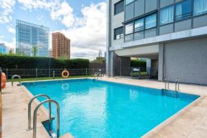 a large blue swimming pool next to a building at Charming Nuevo Madrid in Madrid