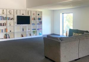 a living room with a couch and a television at For Students Only Ensuite Bedrooms at Westwood Student Mews in Warwick in Coventry