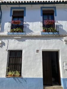 biały budynek z dwoma oknami i drzwiami w obiekcie Amal Casa de huéspedes w Kordobie