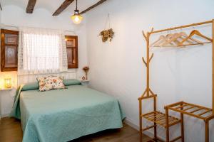 a bedroom with a bed with a green comforter at Casa rural la balsa in Anna