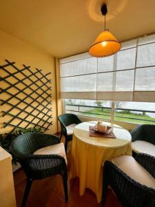 une chambre avec une table, des chaises et une fenêtre dans l'établissement Miño - Playa Lago, à Miño