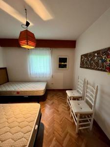 - une chambre avec 2 lits et 2 chaises dans l'établissement Miño - Playa Lago, à Miño