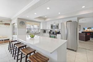 a kitchen with a large white counter top and chairs at 152 Leeward Court in Marco Island