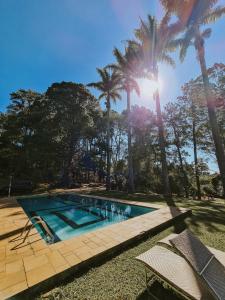 una piscina con palmeras en el fondo en Sitio Santa Filomena, en Vinhedo