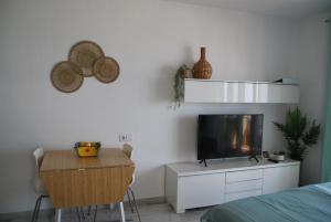 - une chambre avec une télévision, une table et un lit dans l'établissement Studio 1 - Sea front, à Rincón de la Victoria