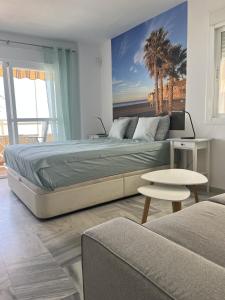 um quarto com uma cama grande e um sofá em Studio 1 - Sea front em Rincón de la Victoria