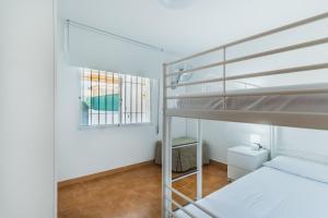 sypialnia z dwoma łóżkami piętrowymi i oknem w obiekcie Dúplex junto a la playa w mieście Sanlúcar de Barrameda