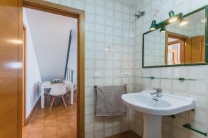 W łazience znajduje się umywalka, lustro i stół. w obiekcie Dúplex junto a la playa w mieście Sanlúcar de Barrameda