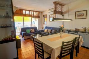 eine Küche und ein Wohnzimmer mit Tisch und Stühlen in der Unterkunft Oasis Sinia by Hello Homes Sitges in Sitges