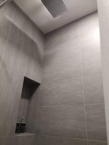 a bathroom with a shower with a tile wall at Romantic Log Cabin 2 - Heart of KL, near KLCC/KL Tower in Kuala Lumpur