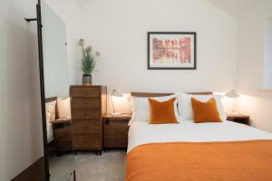 a bedroom with a bed with orange pillows at Contemporary Home by LetMeStay in Carnforth
