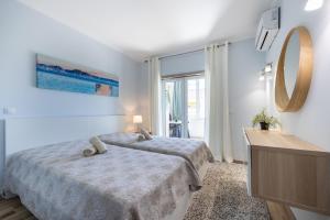 a hotel room with two beds and a mirror at Convista Flat T2+1 in Portimão +29 photos