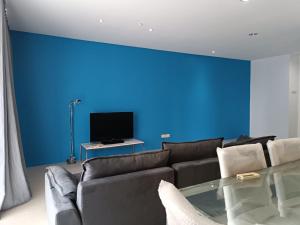 a living room with a couch and a blue wall at Menara Bintang Goldhill in Kuala Lumpur