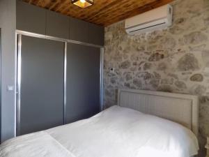 a bedroom with a white bed and a stone wall at Denize sıfır restore edilmiş ahşap tavan taş villa in Bodrum City