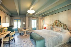 a bedroom with a large bed and a table and chairs at Hospes Las Casas del Rey de Baeza, a Member of Design Hotels in Seville