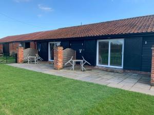 a house with two chairs and a patio at Plumptons Farm Holiday Lodges in Colchester