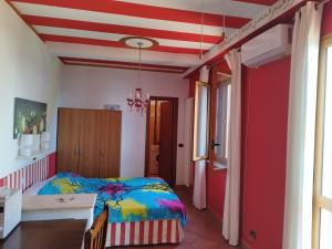 um quarto com uma cama e uma parede vermelha em Villa Kalura D em Cefalù