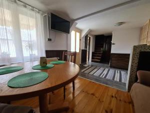 ein Wohnzimmer mit einem Holztisch mit grünen Platten darauf in der Unterkunft Casa Bonita Saliste in Sălişte