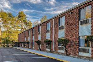 an empty parking lot next to a brick building at Days Inn by Wyndham Brunswick Bath Area in Brunswick