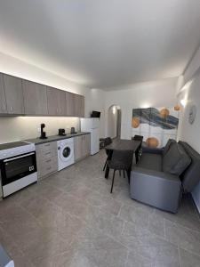 Una cocina con un sofá y una mesa en una habitación. en Petit Homme by Andreas, en Perissa
