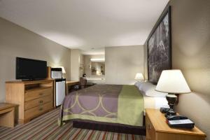 a hotel room with a bed and a flat screen tv at Super 8 by Wyndham Fort Chiswell Wytheville Area in Max Meadows